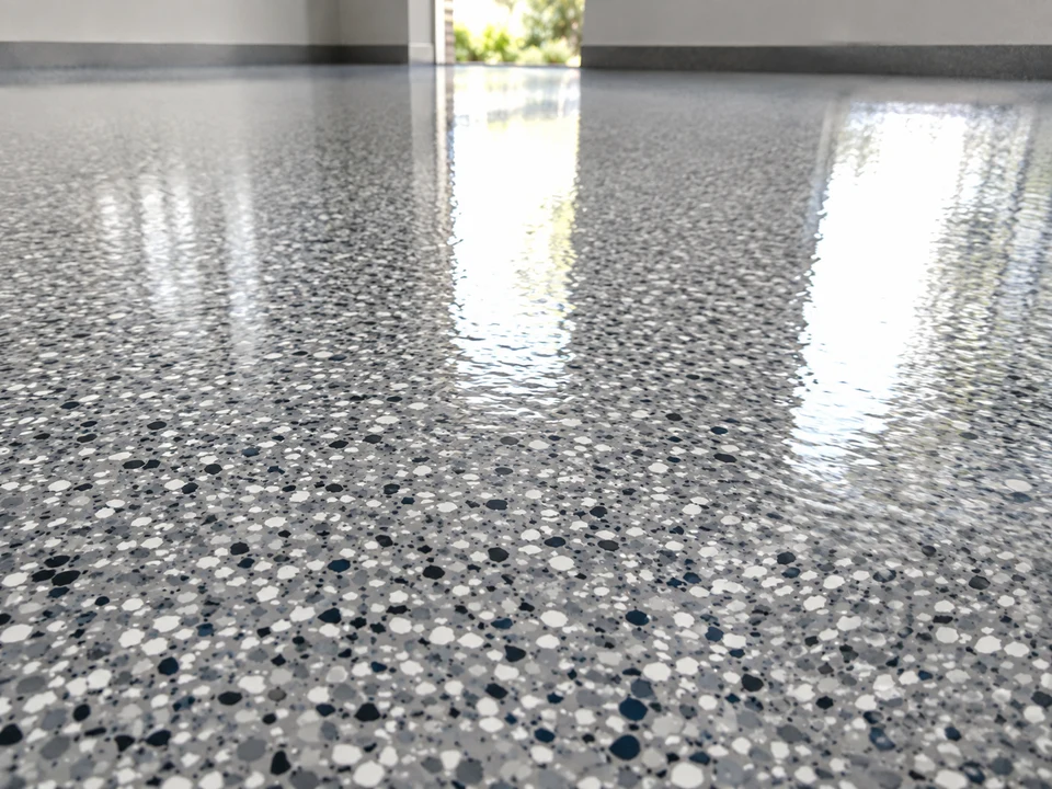 Wide-angle view of a glossy epoxy floor with strong wet-look light reflections